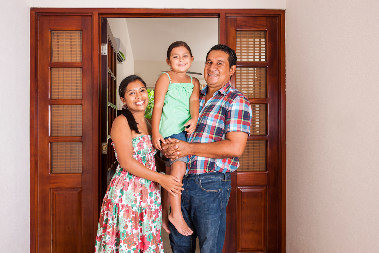Happy latino family in the doorway of their house