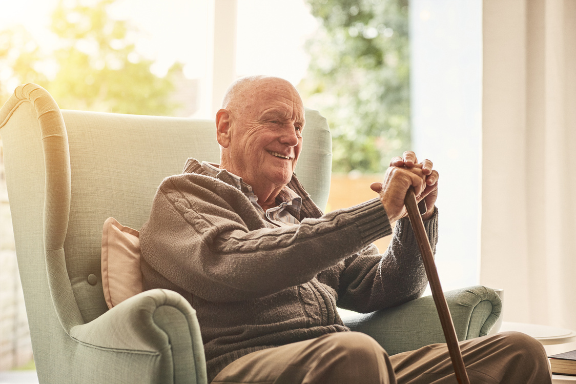 Happy elderly man sitting at home